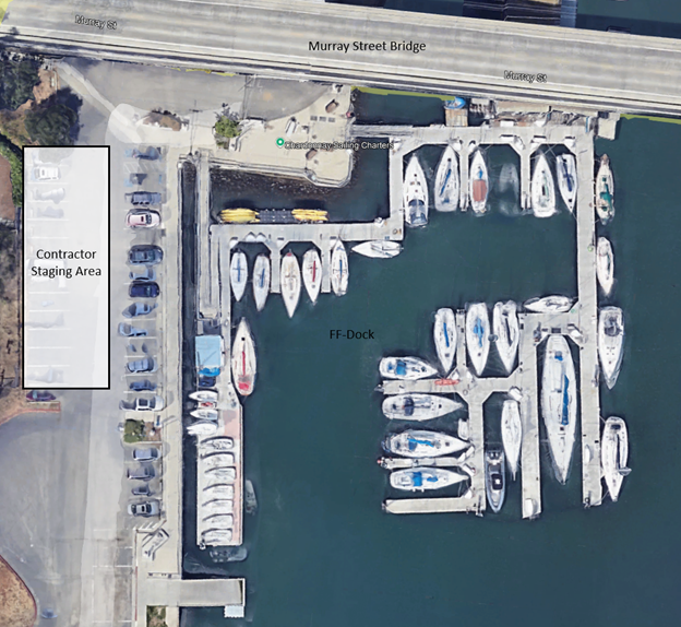 Aerial view of a marina with boats docked, labeled as "FF-Dock" and "Contractor Staging Area" adjacent to a bridge.