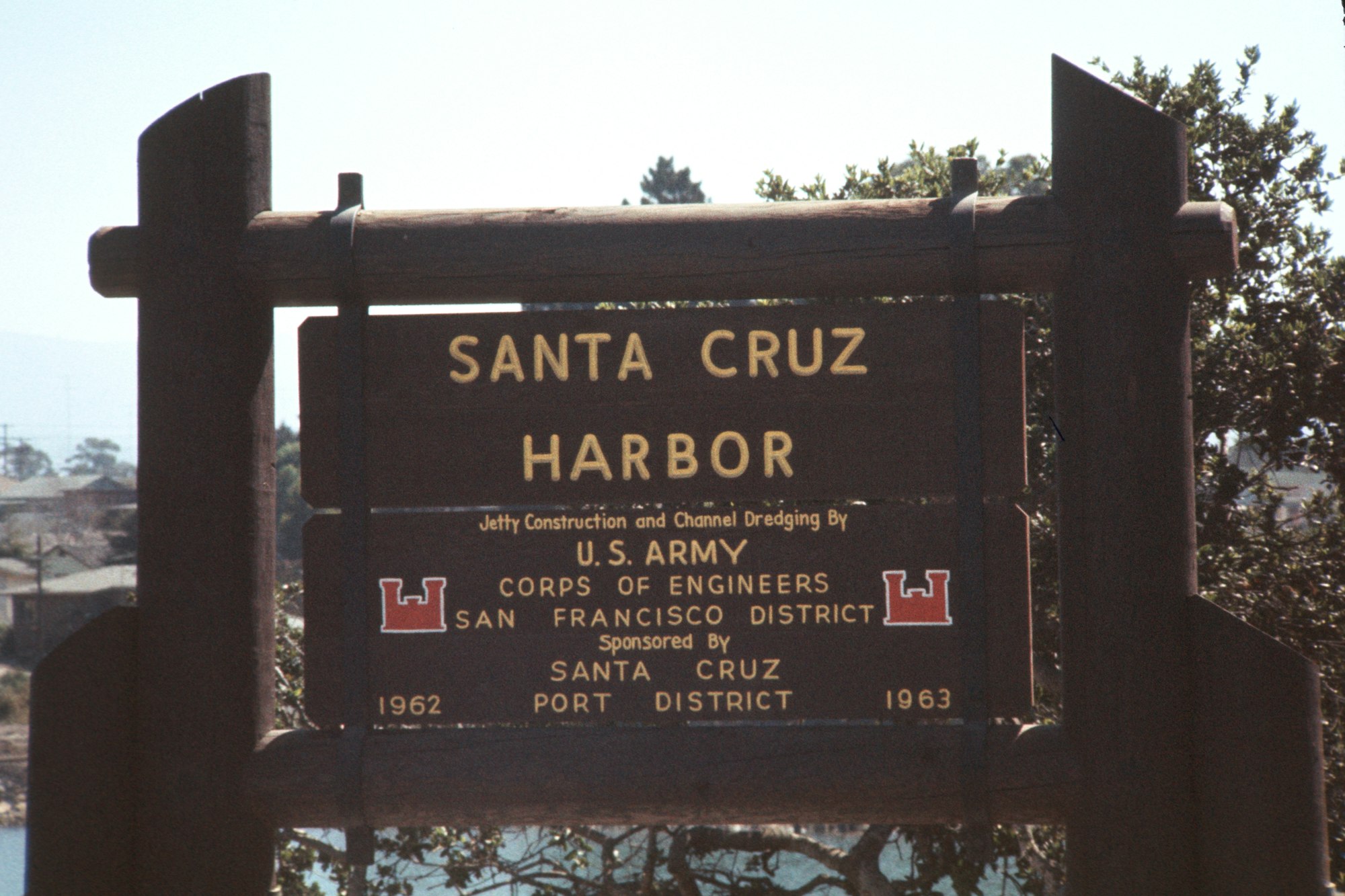 A sign reading "Santa Cruz HARBOR" detailing jetty construction and channel dredging by the U.S. Army Corps of Engineers, 1962-1963.