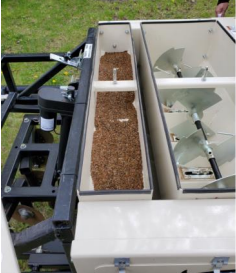 Agricultural seed planter with seeds in hopper.