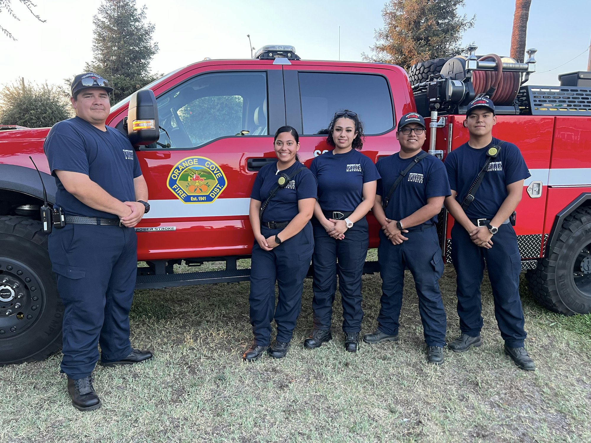 Group of fire fighters standing in front of a fire truck