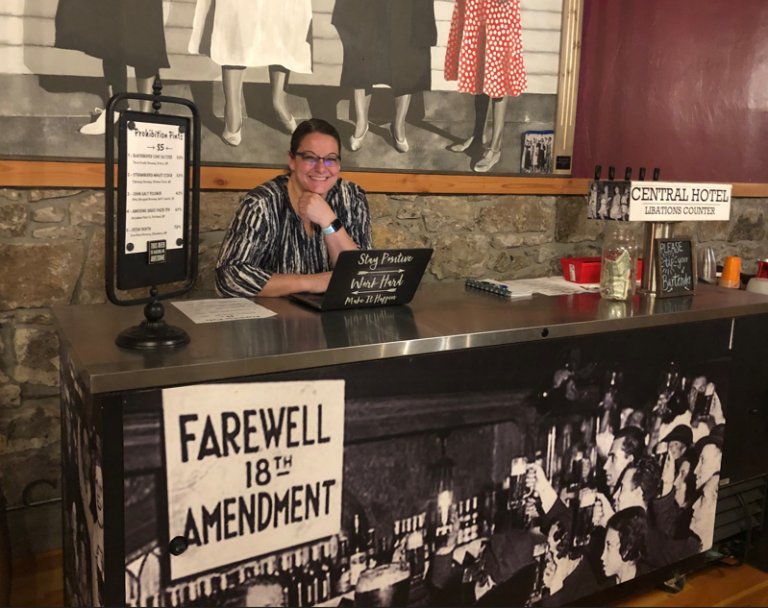 A person behind a counter with a "Farewell 18th Amendment" sign, evoking a prohibition era vibe.