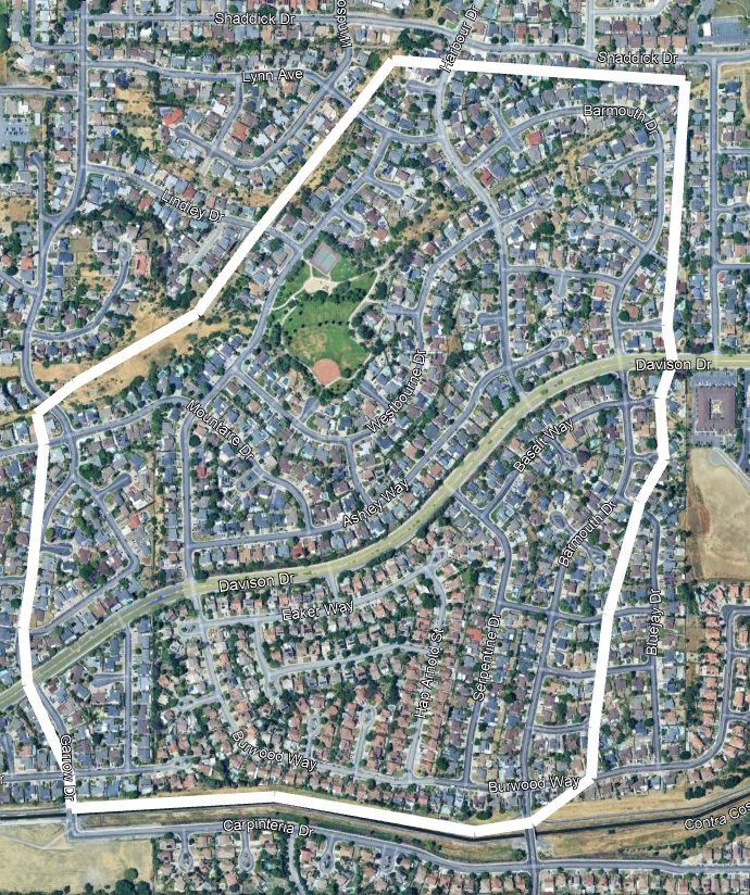Aerial view of a residential neighborhood with winding streets, houses, a park, and a sports field outlined by a white border.
