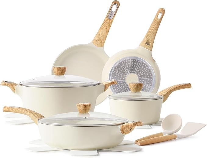 A set of cream-colored cooking pots and pans with wooden handles, lids, and kitchen utensils.