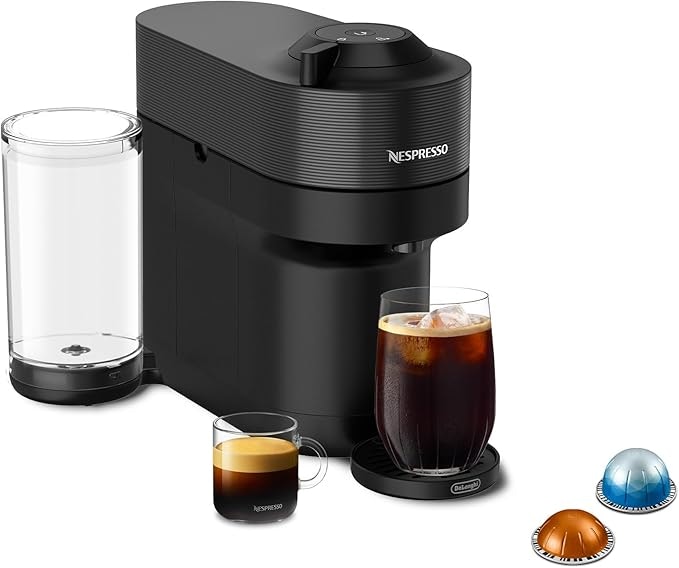 Black Nespresso coffee machine with two cups (espresso and iced coffee) and three coffee pods.