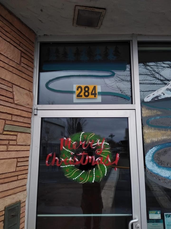 Door with a "Merry Christmas" sign and a painted wreath. House number 284.