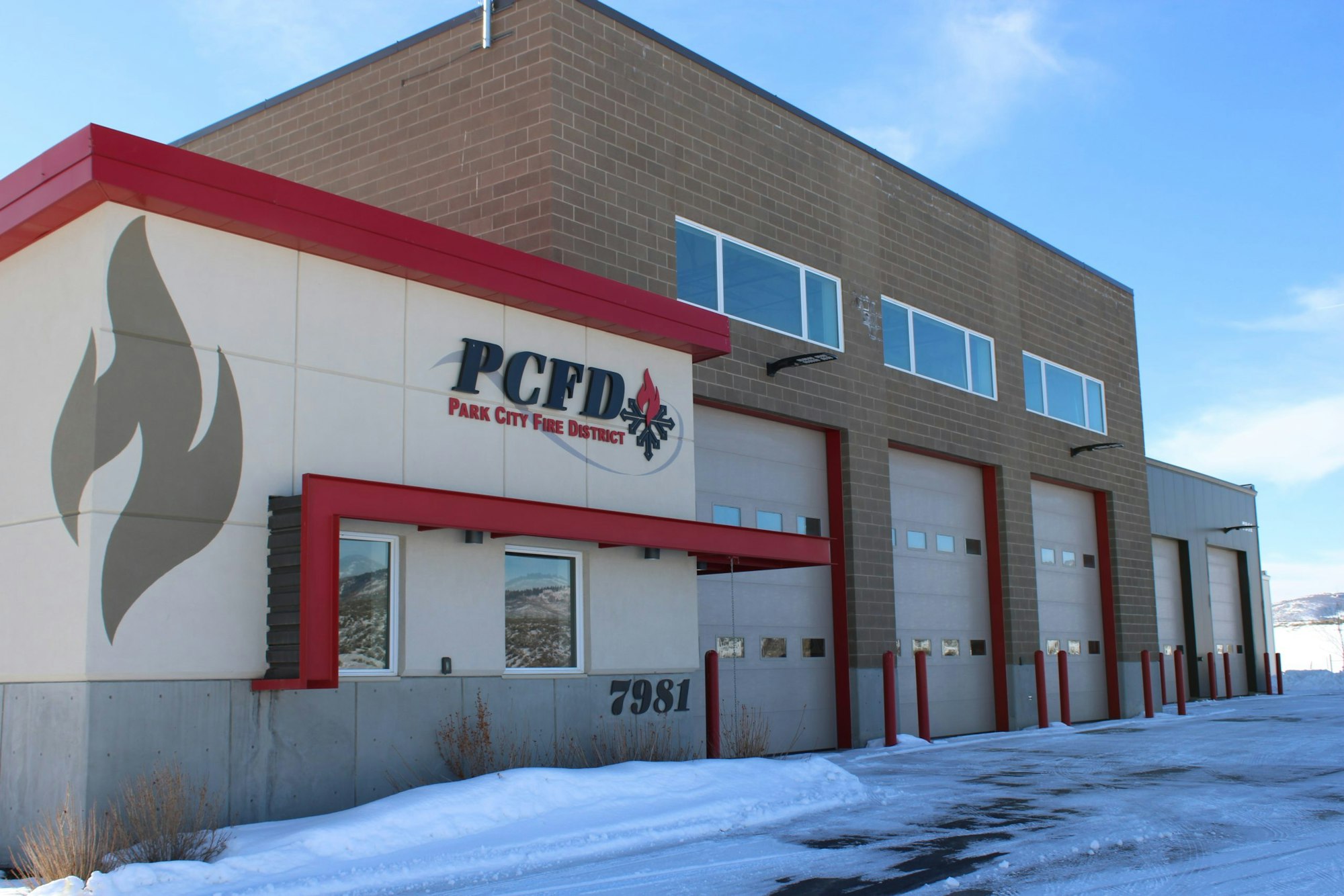The image shows the Park City Fire District building, featuring a modern design with fire-related graphics and large garage doors.