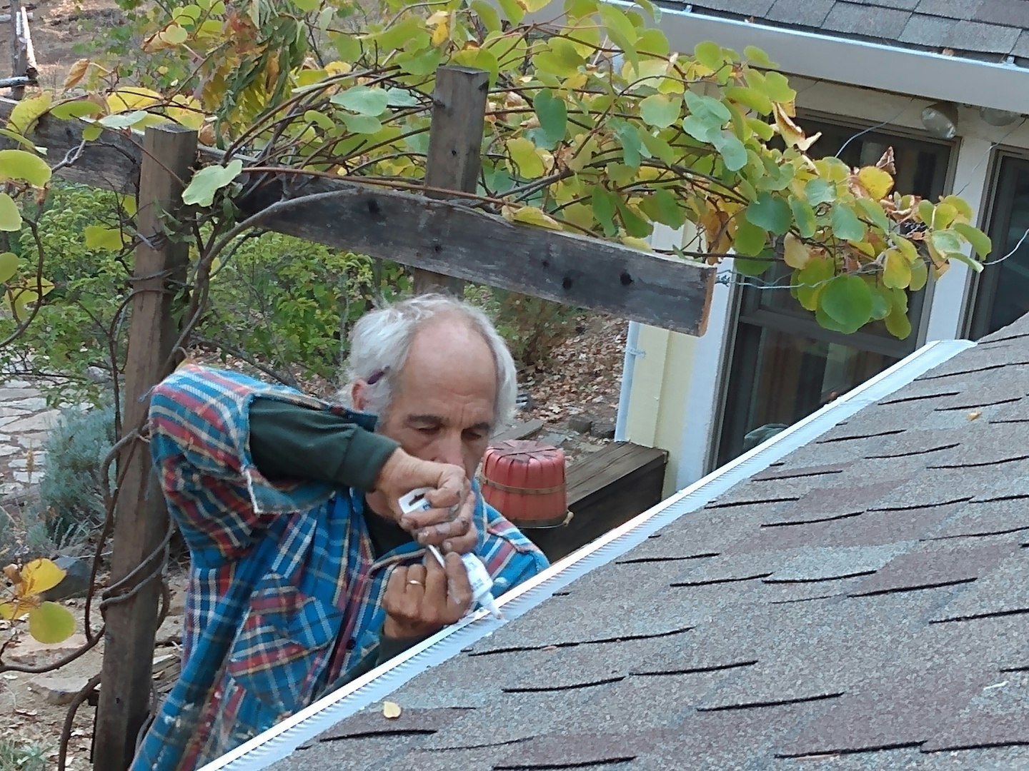 Squeezing silicone caulking on gutter guards