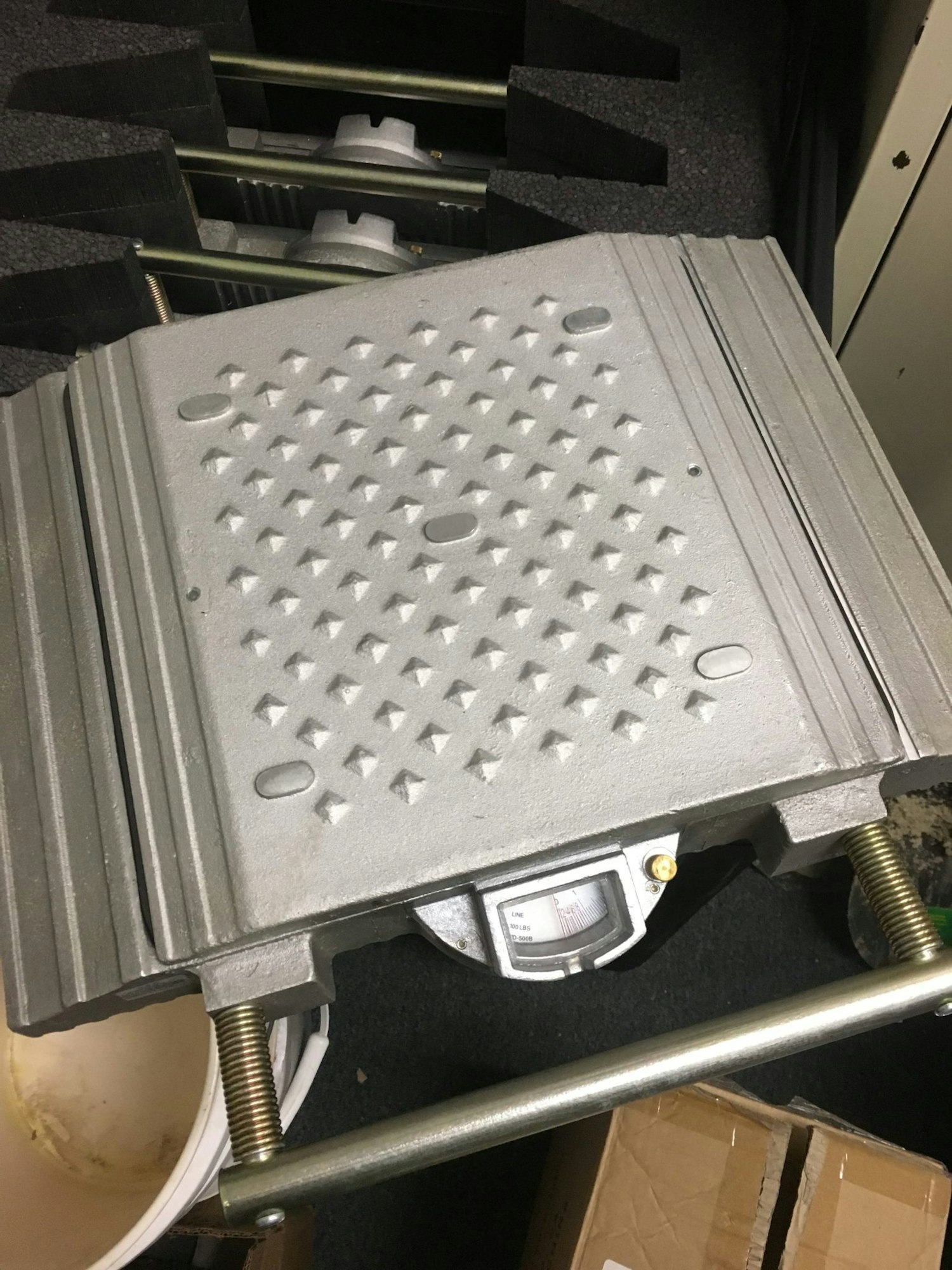 A metal weight plate on a gym rack.
