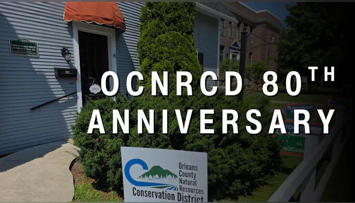 The image highlights the 80th anniversary of the Orleans County Natural Resources Conservation District, featuring their sign and building.