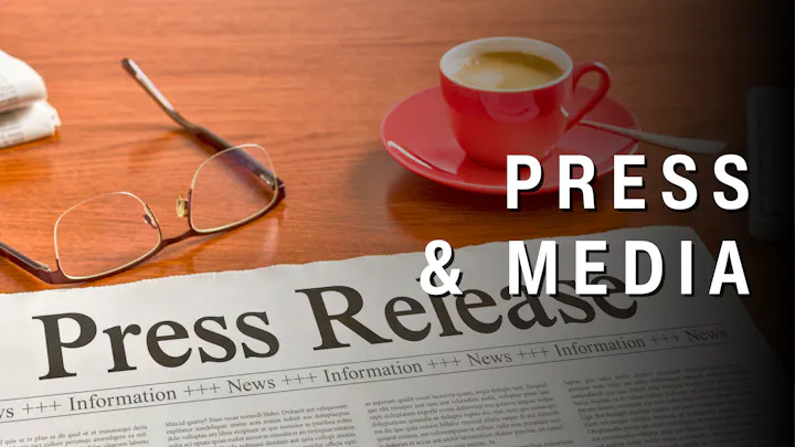 The image features a "Press Release" document, glasses, and a cup of coffee on a table, highlighting media and communication themes.