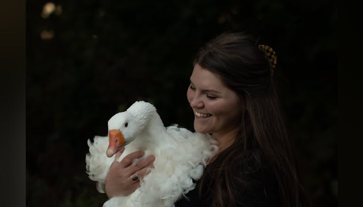 District staff member, Rebekkah, holding one of her beloved geese in her arms