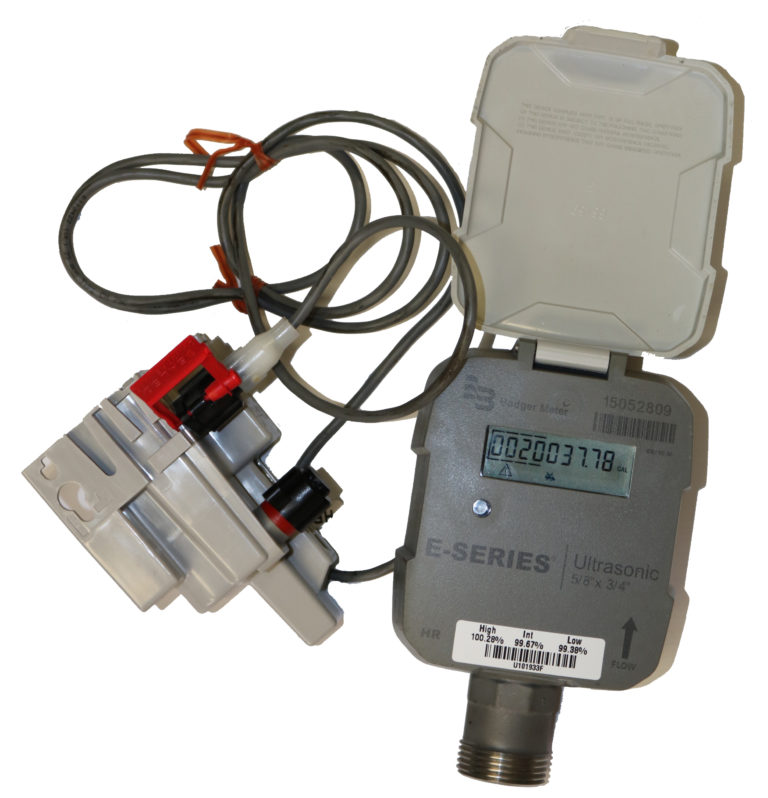 An ultrasonic water meter with cables and connectors.
