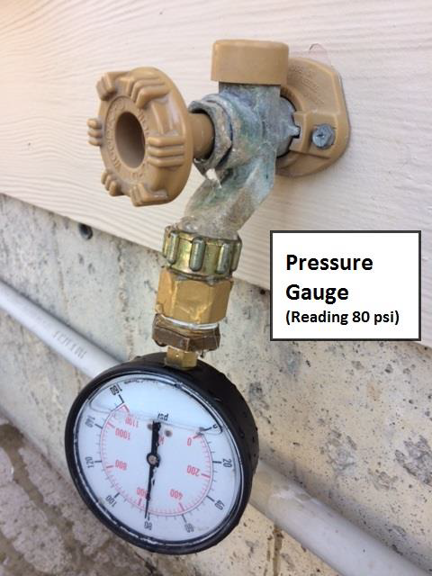 An outdoor water faucet with a pressure gauge attached, showing a reading of 80 psi.
