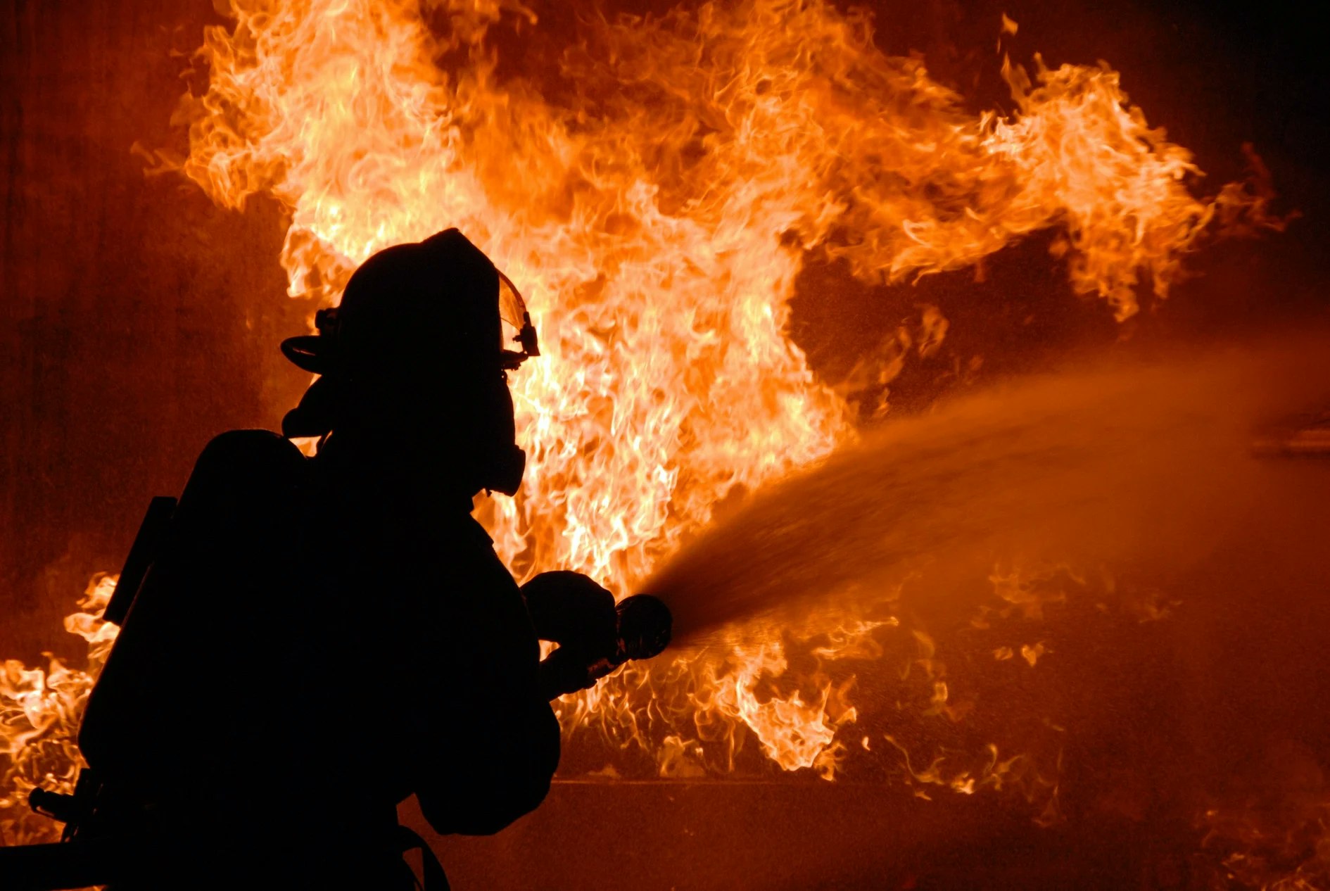 firefighter spraying water on fire