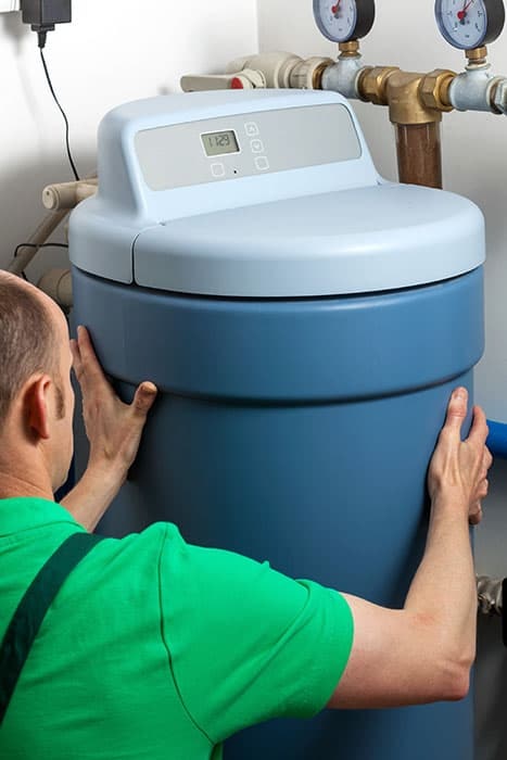 Person installing a water softener system.