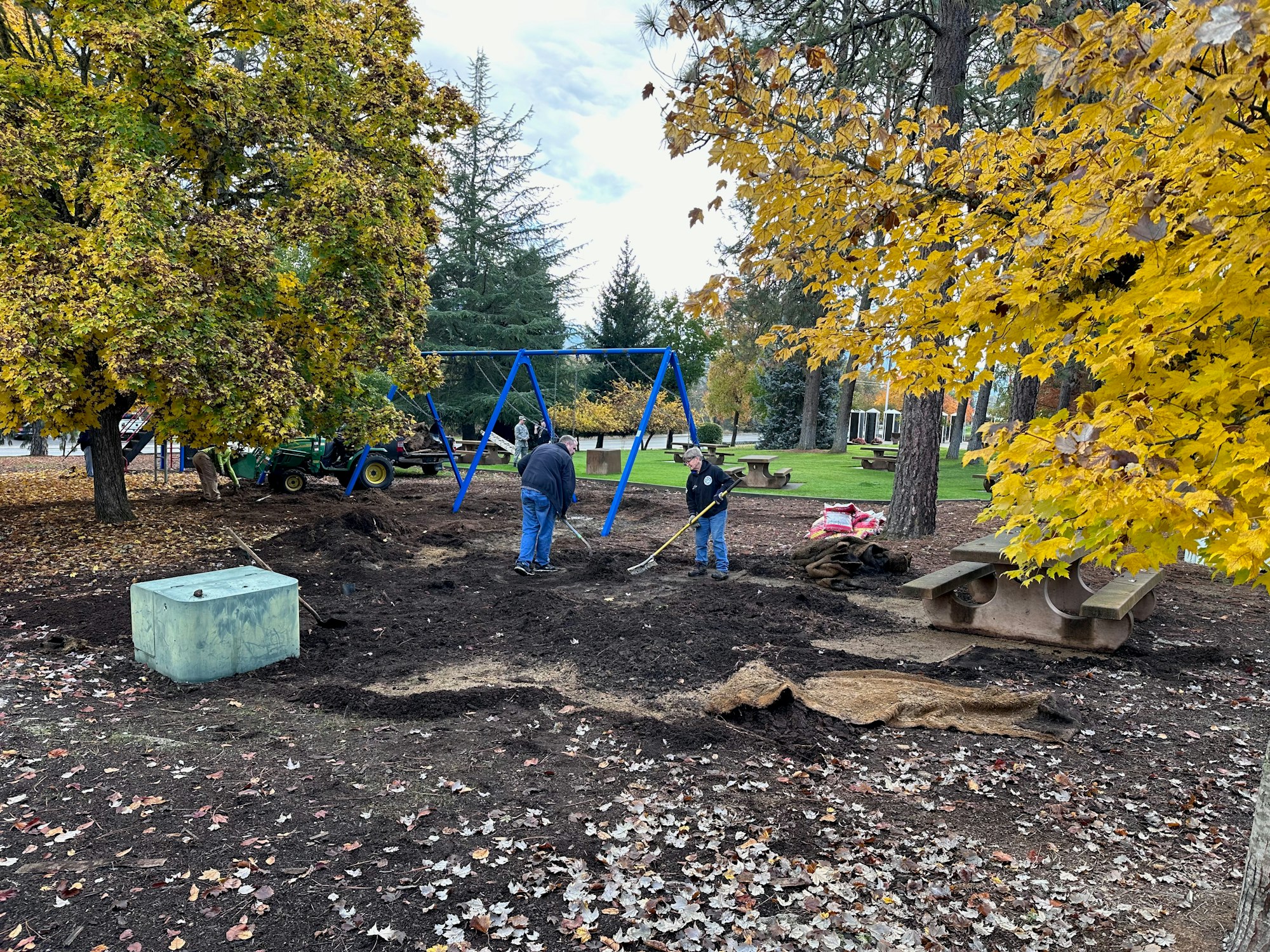 May contain: plant, tree, grass, nature, outdoors, park, person, play area, outdoor play area, clothing, footwear, shoe, device, shovel, and tool