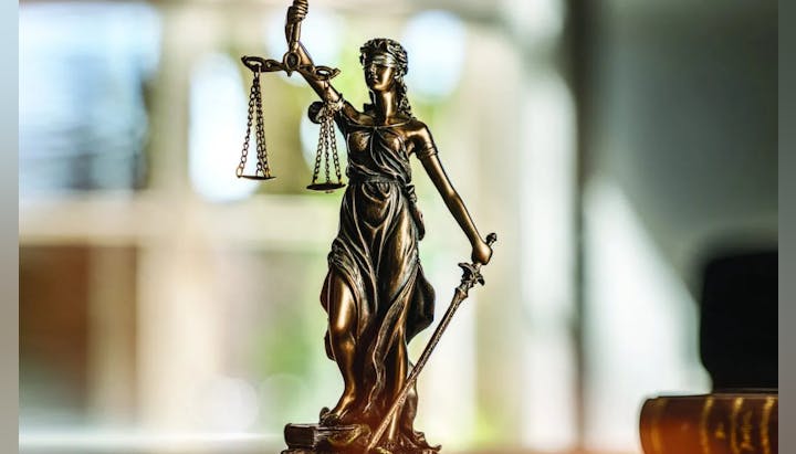 A statue of Lady Justice holding scales and a sword, symbolizing the fair administration of law.