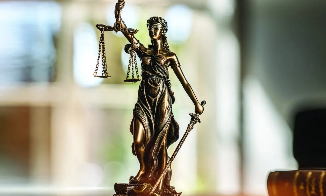 A statue of Lady Justice holding scales and a sword, symbolizing the fair administration of law.