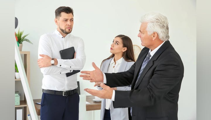 Three professionals in a discussion, possibly a disagreement, in an office setting.