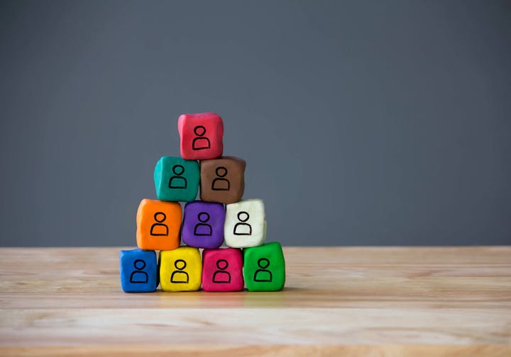 Colorful blocks with "Do" written on them, stacked on a wood surface against a gray background.