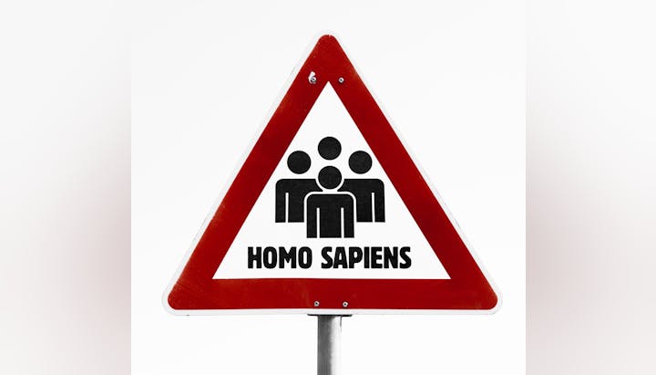 A triangular sign with people icons and the text "Homo Sapiens" in bold lettering.