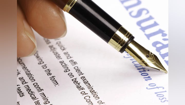A close-up of a fountain pen on paper with blurred text.