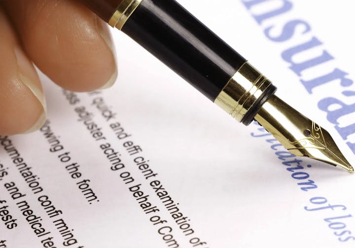 A close-up of a fountain pen on paper with blurred text.
