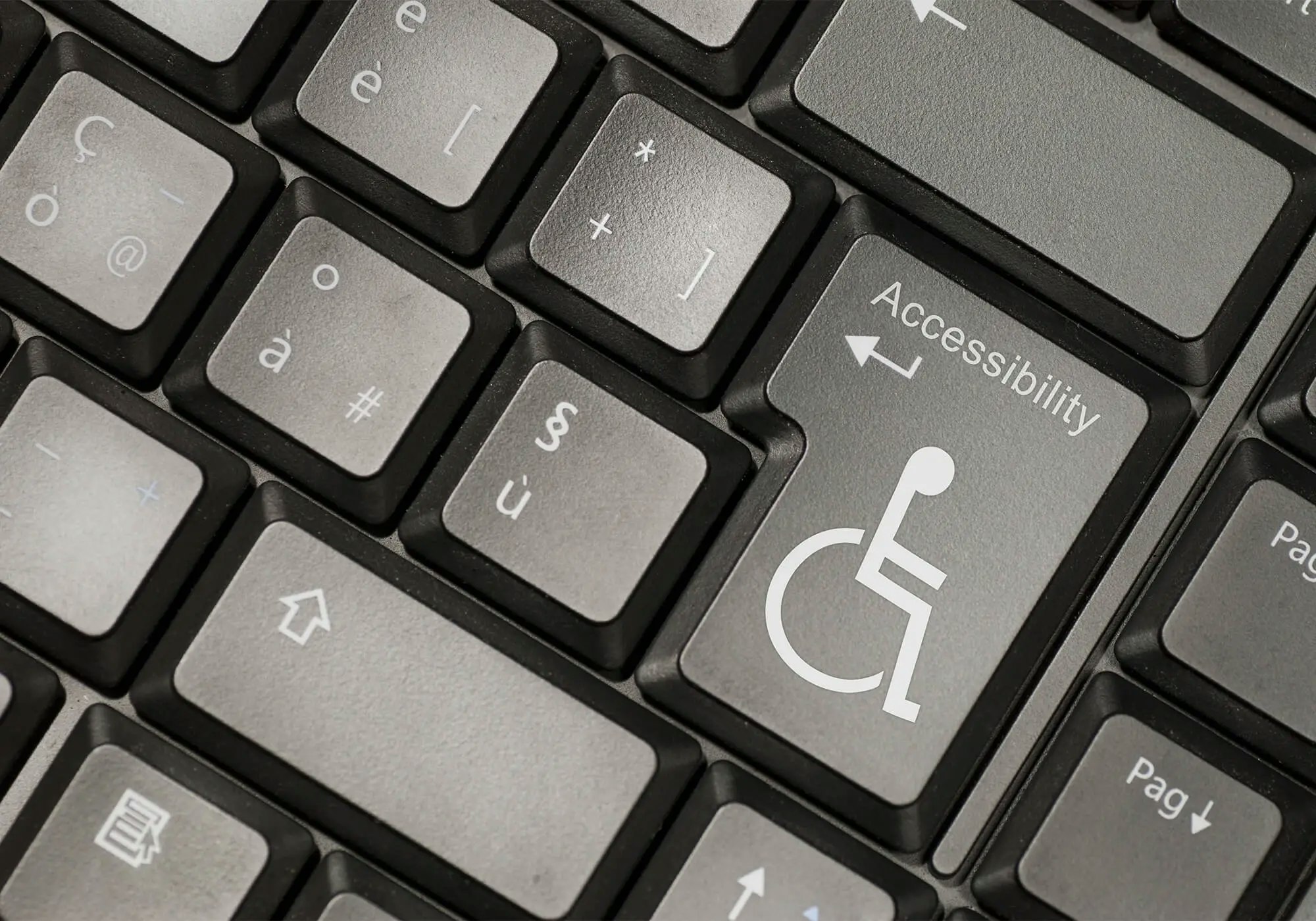 Close-up of a keyboard with an "Accessibility" key featuring the International Symbol of Access (wheelchair symbol).