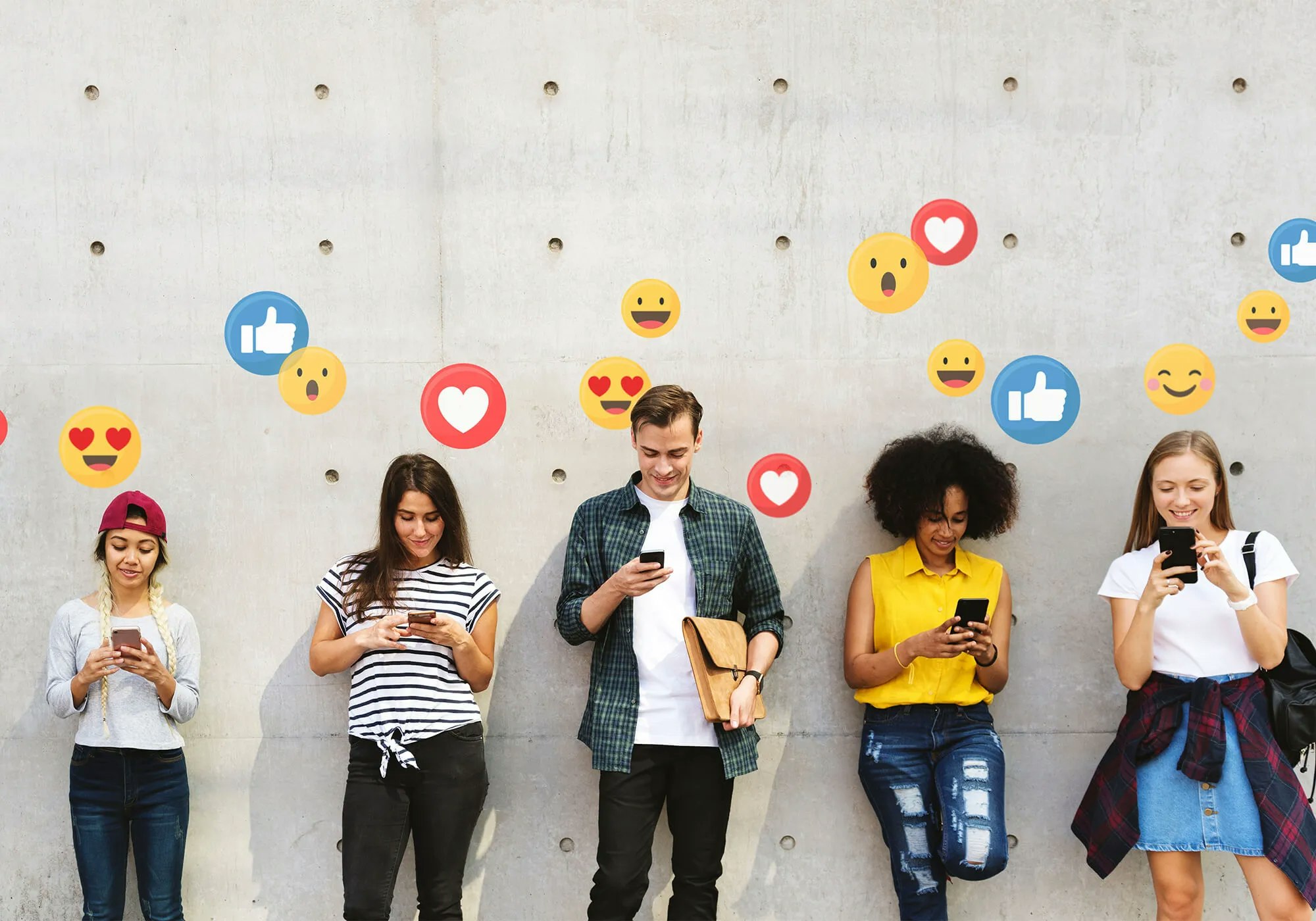 Group of young people using smartphones with social media reaction icons floating above.