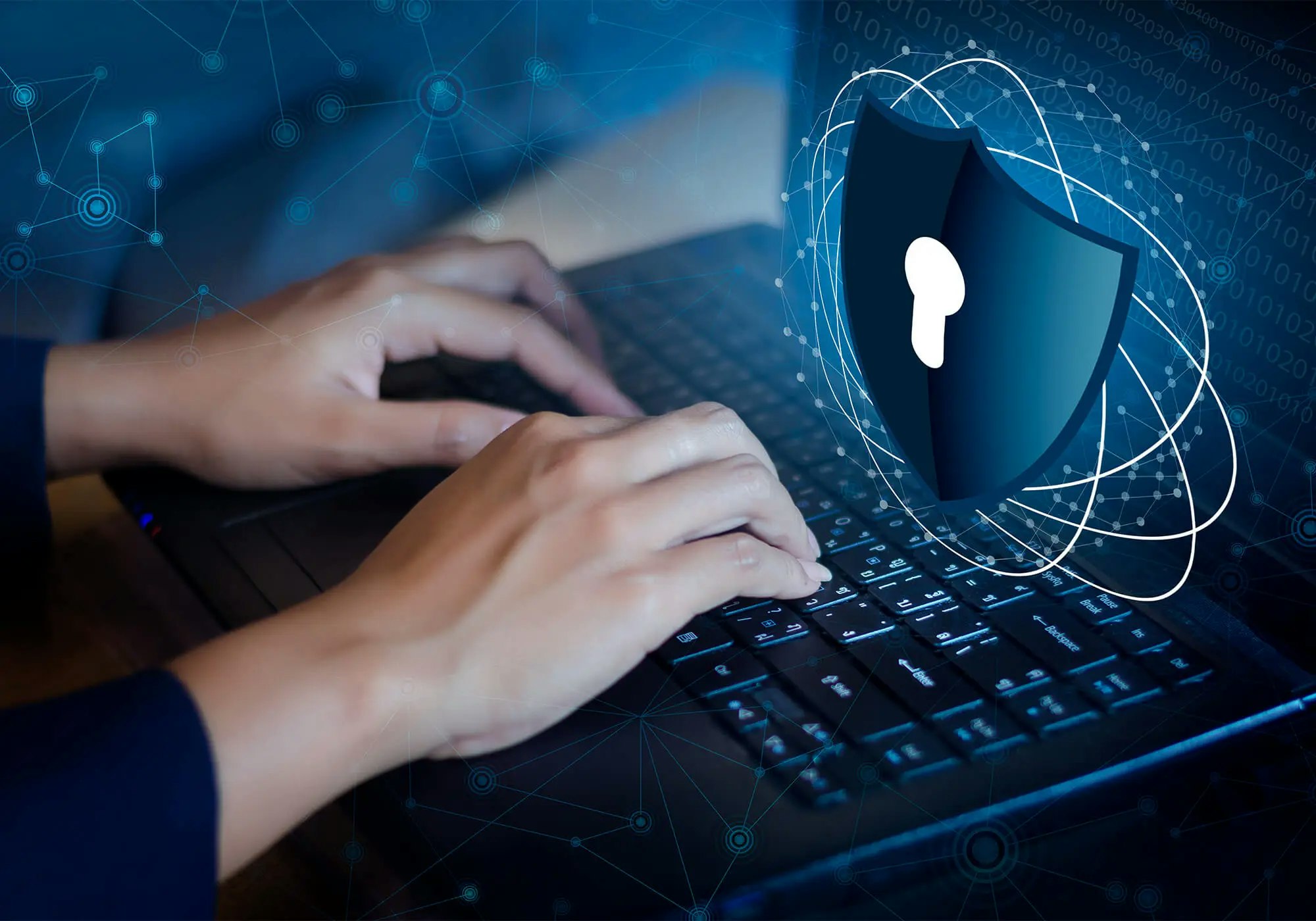 Hands typing on a laptop with a digital overlay of a shield and network connections, symbolizing cybersecurity.