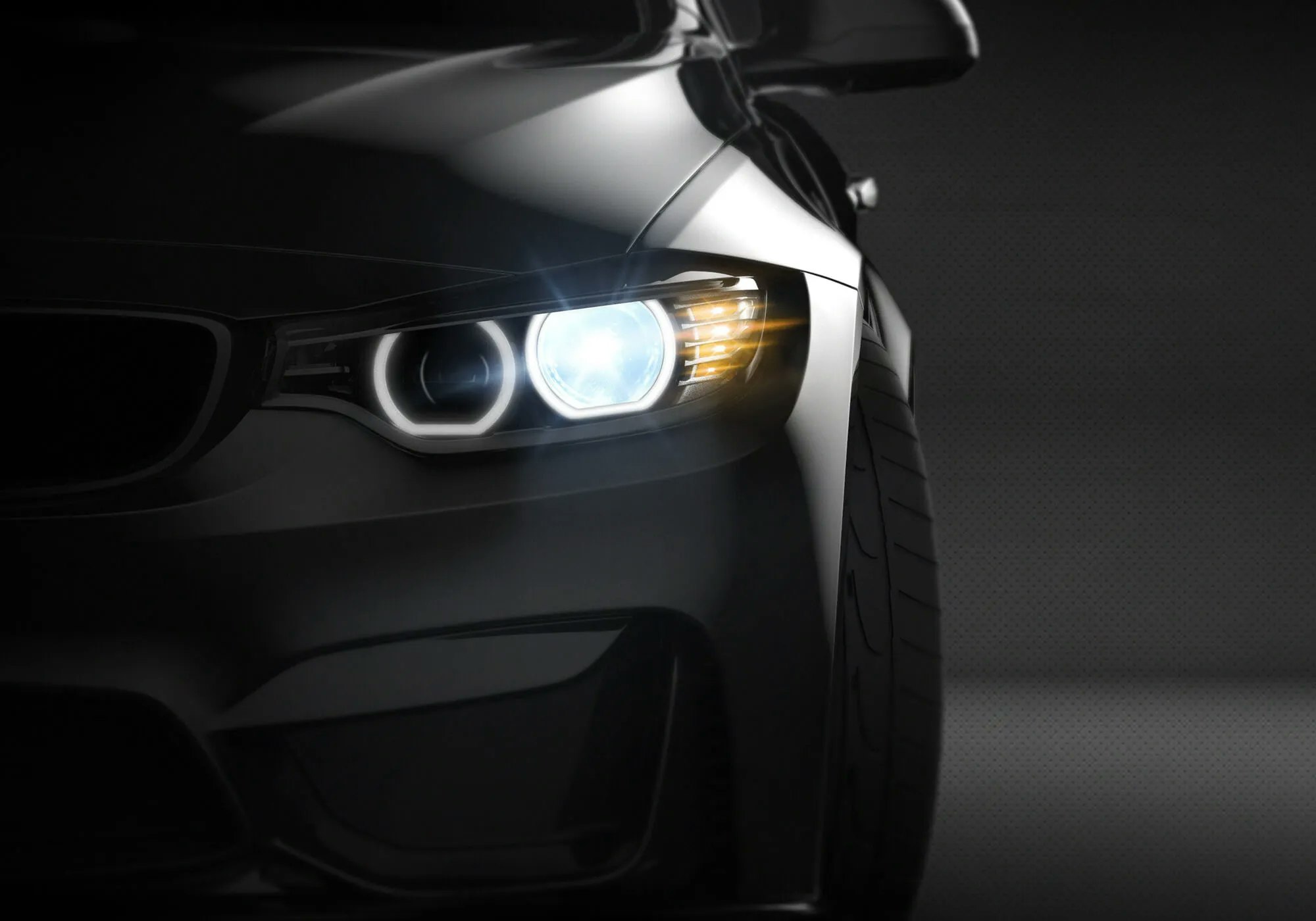 Close-up of a car's front headlight and grille, evoking a sense of luxury and power.