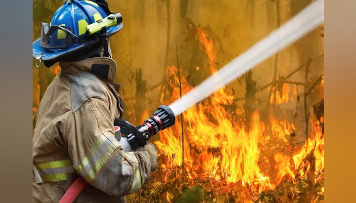 A firefighter extinguishes a blaze.