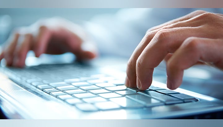 Hands typing on a laptop keyboard.