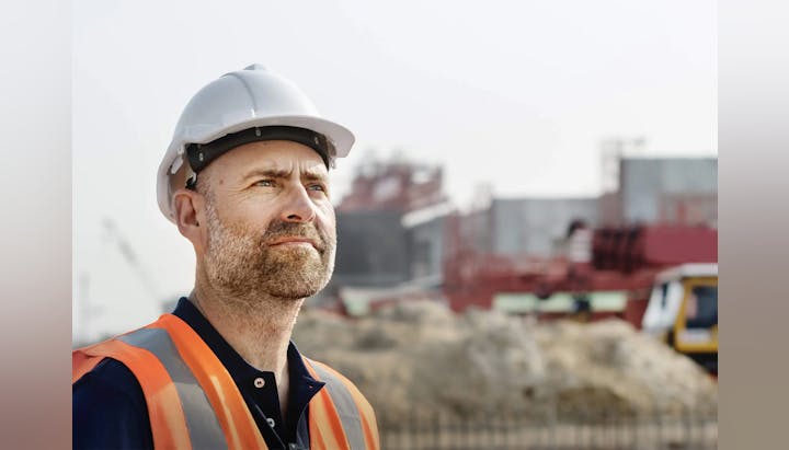 A man in a hard hat at a construction site.