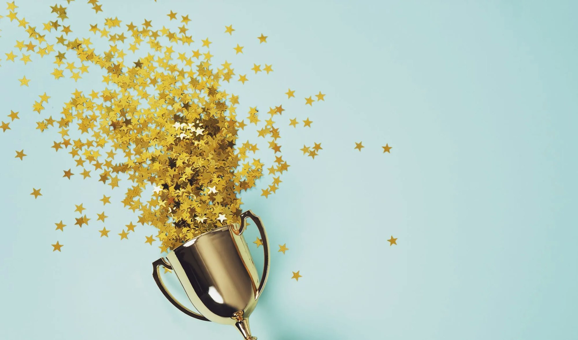 Golden trophy with star-shaped confetti on a blue background.