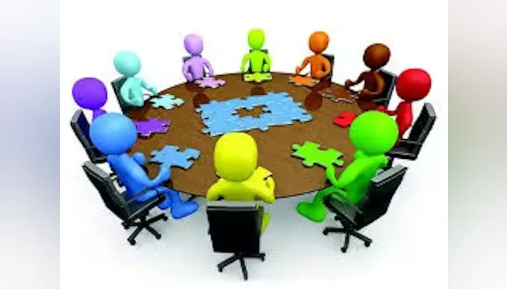 Colorful 3D figures at a round table, assembling puzzle pieces.