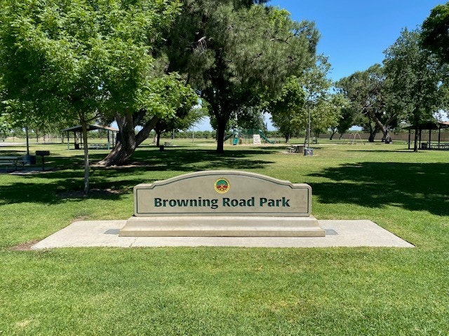 Sign for "Browning Road Park" with green trees and lawn in the background.
