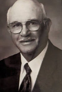 May contain: photography, accessories, formal wear, tie, face, head, person, portrait, glasses, clothing, suit, adult, male, man, and coat