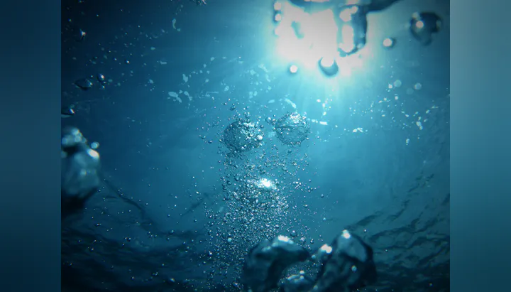 An underwater scene showing sunlight filtering through water, with bubbles and a vibrant blue background.