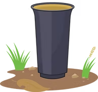 The image depicts a large cup standing on the ground, surrounded by some grass and dirt.