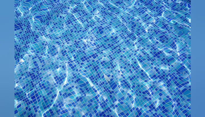Mosaic pattern tiles under water with rippling and reflections.