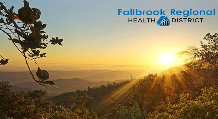 A scenic view of mountains and a sunset, with the "Fallbrook Regional Health District" logo in the corner.