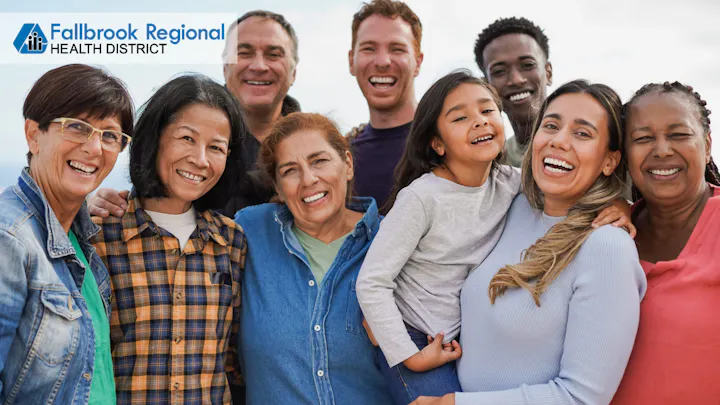 A diverse group of smiling people posing together outdoors, showcasing joy and community. The logo for Fallbrook Regional Health District is visible.