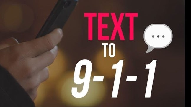 Image of hand holding a cell phone and "TEXT TO 9-1-1" in red and white letters.