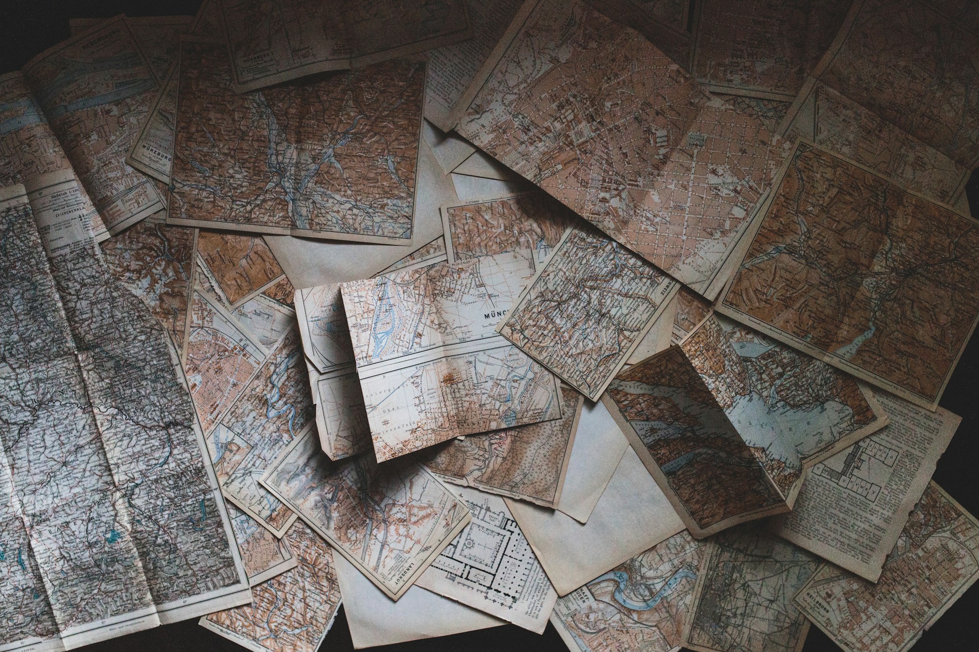 Maps haphazardly placed on a table.