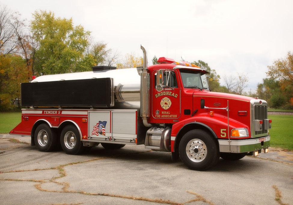 A red fire department water tender truck parked outdoors.