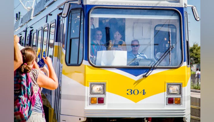 A tram with passengers, number 304, and a person outside taking a photo.