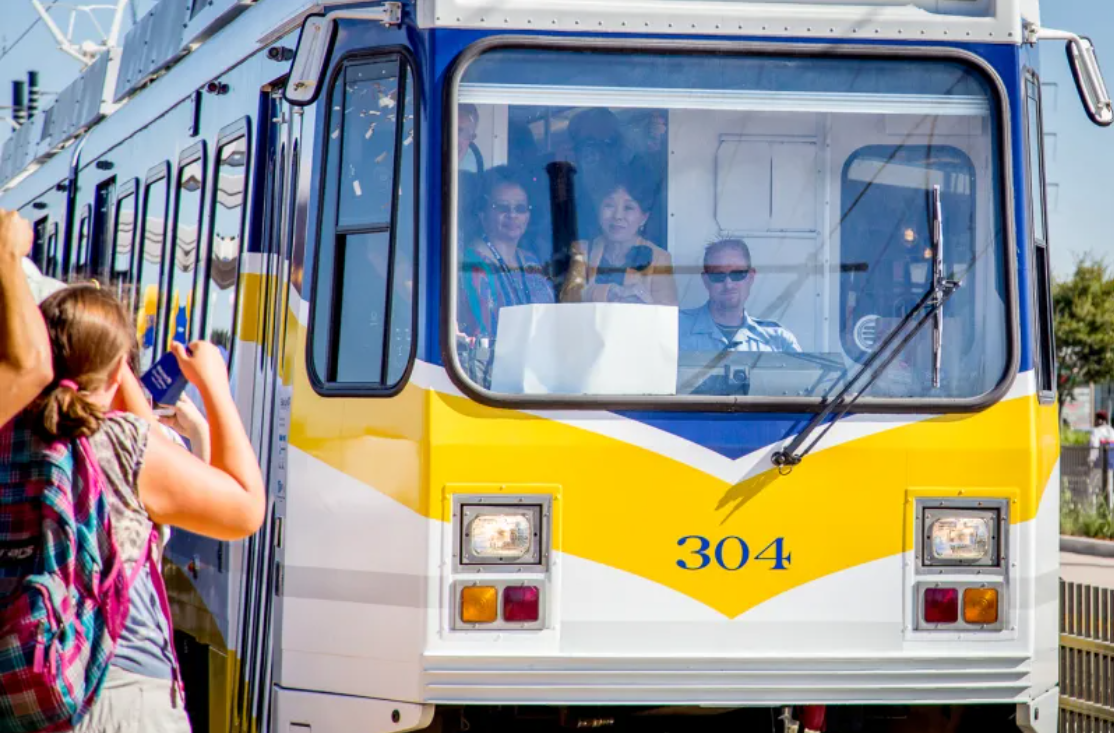 A tram with passengers, number 304, and a person outside taking a photo.