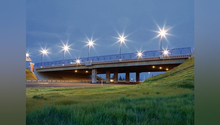 An overpass bridge at twilight with streetlights on.