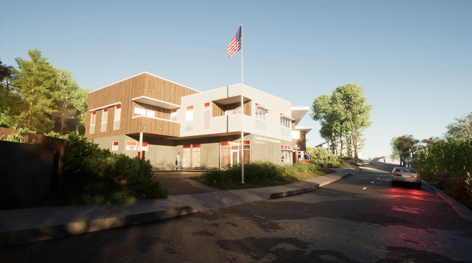 Modern fire station with an American flag, person walking, and vehicles on a sunny day.
